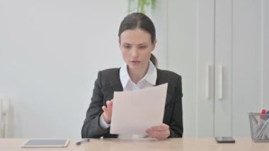 Young Businesswoman Upset by Loss while Reading Business Report