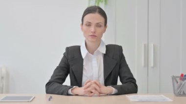 Confident Serious Businesswoman Sitting in Office