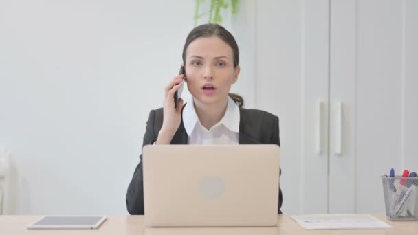 Δυσαρεστημένη Νεαρή Επιχειρηματίας Μιλώντας Θυμωμένα Στο Smartphone Στην Εργασία — Αρχείο Βίντεο