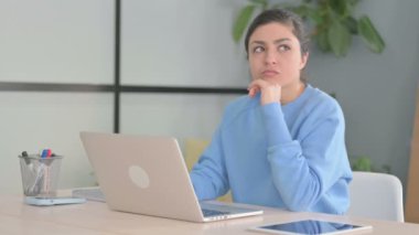 Dizüstü bilgisayarda çalışırken düşünen Hintli kadın.