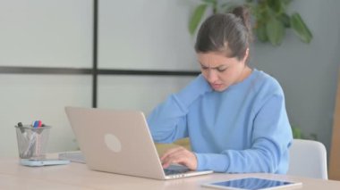 Dizüstü bilgisayar kullanırken boynu ağrıyan Hintli kadın