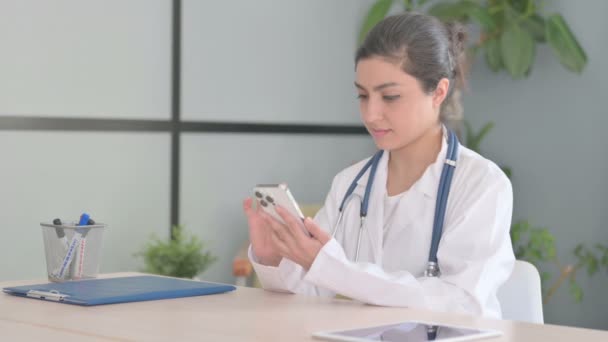 Young Indian Doctor Browsing Smartphone Clinic — Stock Video