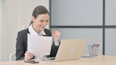 Businesswoman Celebrating Success while Doing Paperwork