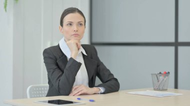 Pensive Businesswoman Thinking while Sitting at Work