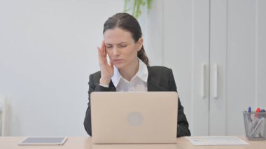 Young Businesswoman having Headache while Working on Laptop