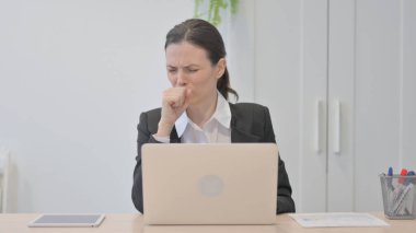 Young Businesswoman Coughing while Working on Laptop