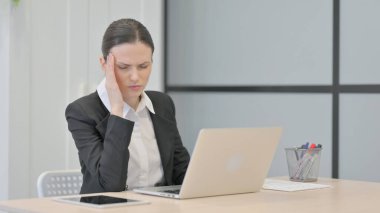 Businesswoman having Headache while Working on Laptop