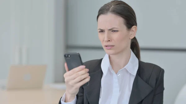 スマートフォンで損失に反応する衝撃的なビジネス女性 — ストック写真