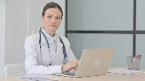 Young Doctor Looking Camera While Using Laptop — Foto de Stock