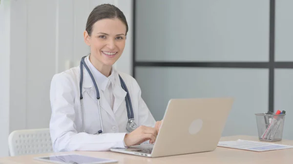 Young Doctor Smiling Camera While Using Laptop — Foto de Stock