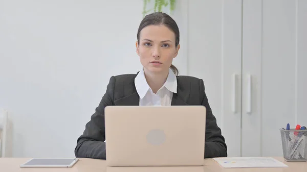 Young Businesswoman Looking Camera While Using Laptop — Stock Fotó