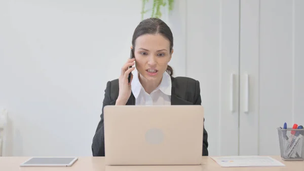 不満なビジネスマン女性は仕事でスマートフォンで怒って話す — ストック写真