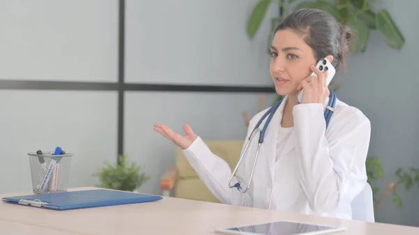Young Indian Doctor Talking on Phone in Clinic