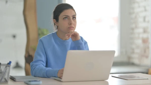 ノートパソコンを使いながら考えるインド人女性 — ストック写真