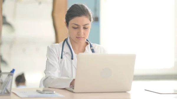 stock image Busy Young Indian Doctor Typing on Laptop in Clinic