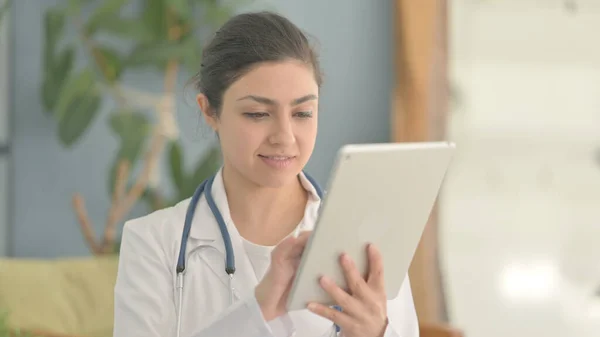Portrait of Young Indian Doctor Browsing Tablet