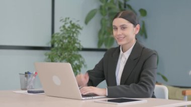 Dizüstü bilgisayardaki Genç İş Kadınından Baş Parmakla