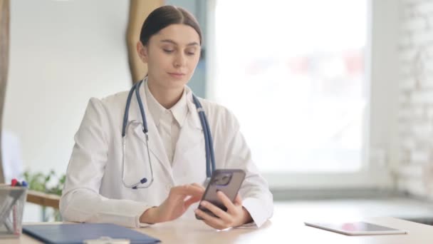 Νεαρή Γυναίκα Γιατρός Χρησιμοποιώντας Smartphone Στην Κλινική — Αρχείο Βίντεο
