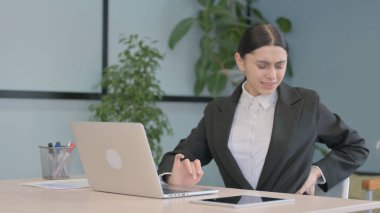 Dizüstü bilgisayarda çalışan, Boyun Ağrısı olan genç Latin İş Kadını