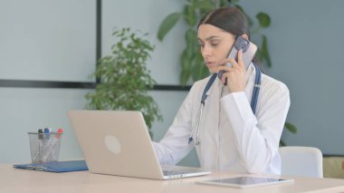 Genç Bayan Doktor Klinikte Telefonda Konuşuyor