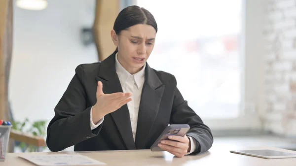 動揺若いビジネスマンの女性はスマートフォンでショックを受ける — ストック写真