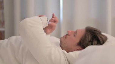 Yetişkin Adam Yatakta Akıllı Saat Kullanıyor