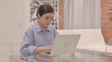 Young Woman Coughing while Working on Laptop