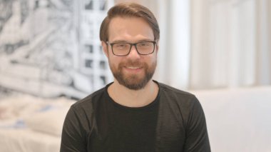 Gülümseyen Genç Yetişkin Adam 'ın Portresi Kameraya Bakıyor