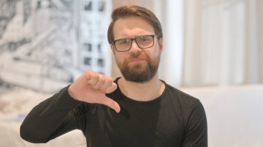 Genç Yetişkin Adam 'ın Başparmaklarını Aşağı Yaparken Portresi