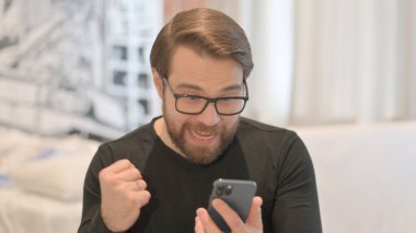 Genç Yetişkin Adam 'ın Akıllı Telefondaki Başarısını Kutlayan Portresi