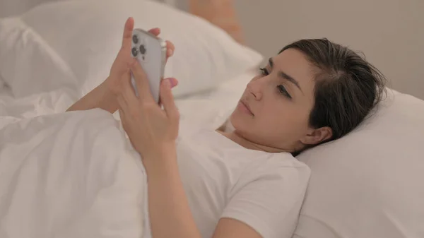 Індійська Молода Жінка Лежачи Ліжку Користується Смартфоном — стокове фото