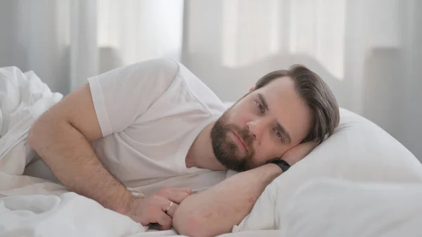 Serious Young Adult Man Lying Bed Side — Stock Photo, Image