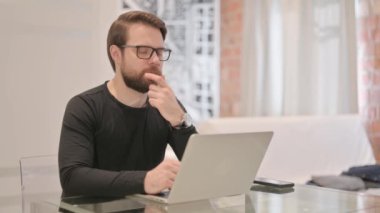 Genç Yetişkin Adam Bilgisayarda Düşünüyor ve Çalışıyor