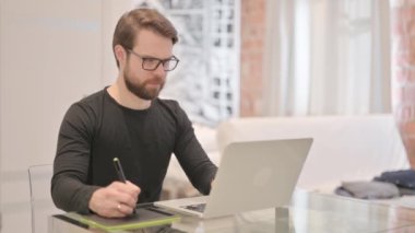 Genç Yetişkin Adam Laptop ve Grafik Tablet Tasarımında Çalışıyor