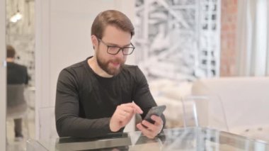Genç Yetişkin Adam Akıllı Telefon 'da Başarı Kutlaması