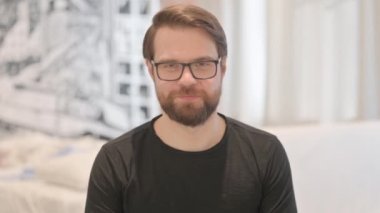 Gülümseyen Genç Yetişkin Adam 'ın Portresi Kameraya Bakıyor