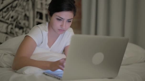 Nuori Nainen Työskentelee Kannettavan Tietokoneen Kun Makaa Vatsa Sängyssä — kuvapankkivideo