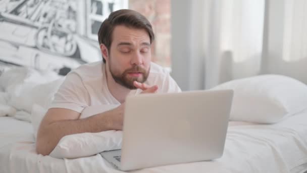 Jonge Volwassen Man Geschokt Door Verlies Laptop Tijdens Het Liggen — Stockvideo