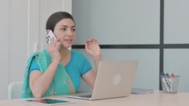 İş yerinde konuşan genç Hintli kadın.