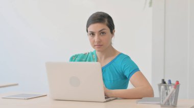 Sari 'deki Hintli Kadın Dizüstü bilgisayarla çalışırken kameraya bakıyor