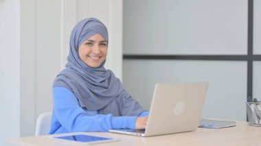 Başörtülü Müslüman Kadın Bilgisayarda Çalışırken Kameraya Gülümsüyor