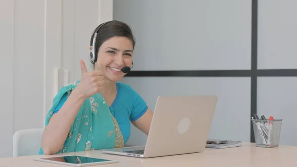 Thumbs Up by Young Indian Woman with Headset Working on Laptop in Call Center
