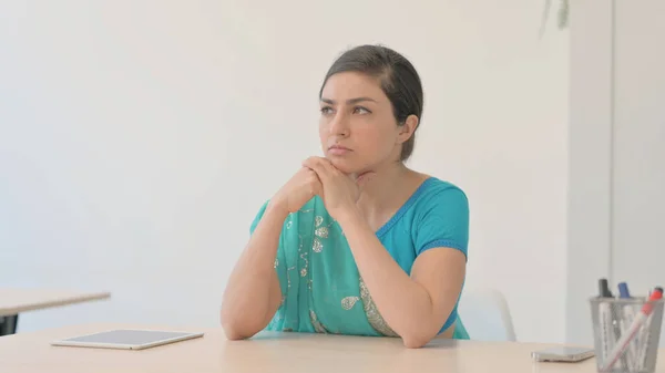 Pensive Indian Woman in Sari Thinking while Sitting at Home
