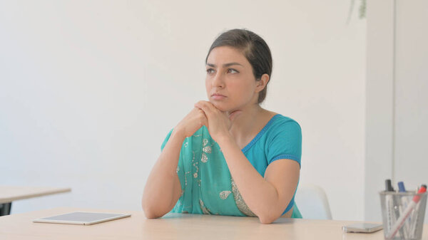 Индийская женщина в Сари думает, сидя дома