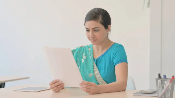 Indian Woman in Sari Reading Documents at Work, Contract