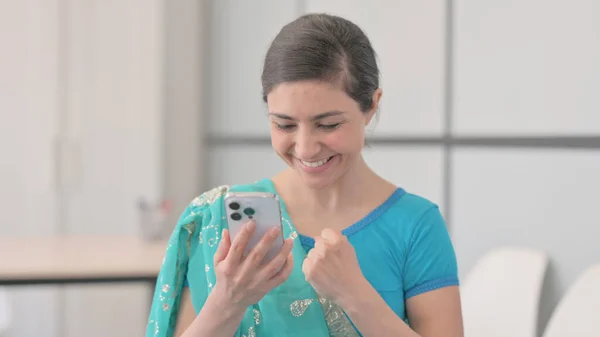 Portrait of Indian Woman in Sari Celebrating Success on Smartphone