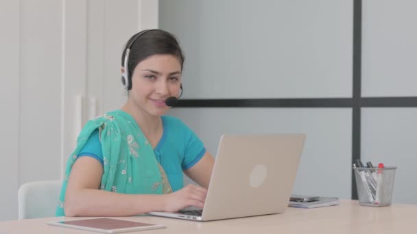 コールセンターのカメラで笑顔のヘッドセットを持つ若いインド人女性 — ストック動画