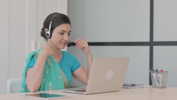 コールセンターでお客様とオンラインで話すヘッドセットを持つ若いインド人女性 — ストック動画