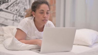 Afro-Amerikan Kadın Laptop 'ta çalışırken Yatakta Mide Uzanıyor