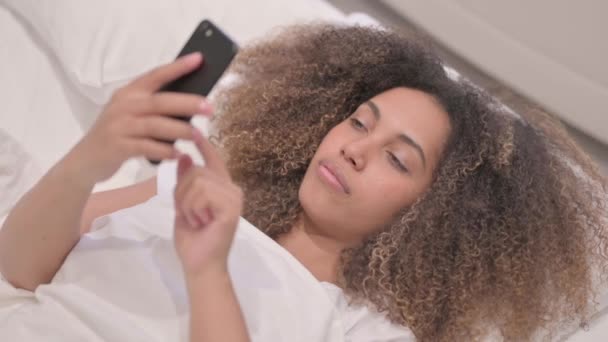 アフリカ系アメリカ人女性がベッドで電話で話す — ストック動画